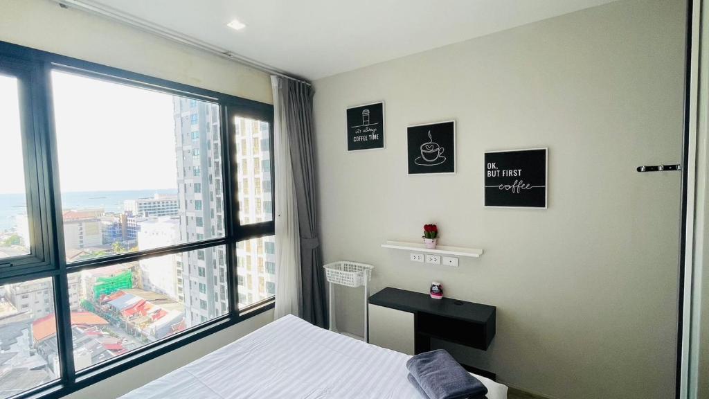 a bedroom with a bed and a large window at The base Central Pattaya 271 by Numam in Pattaya Central