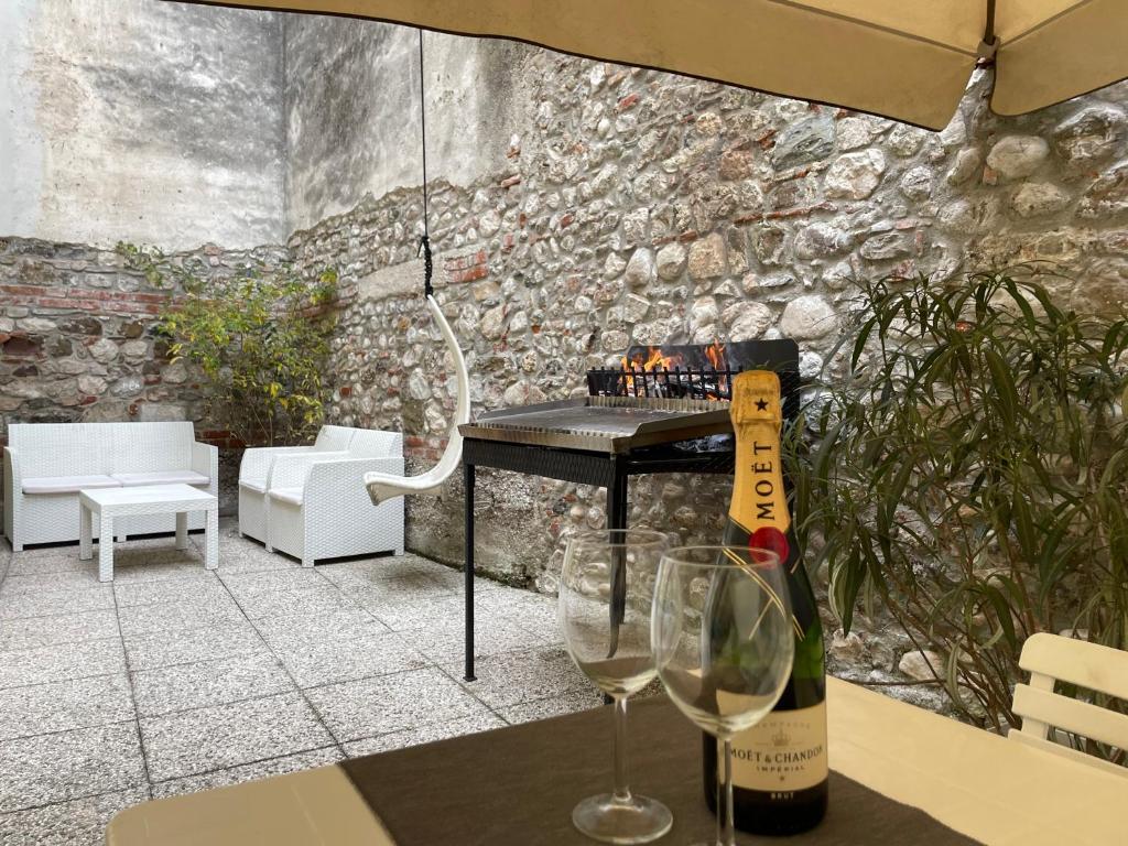 un tavolo con una bottiglia di vino e due bicchieri di Oasi Verde con Area Barbecue a Udine