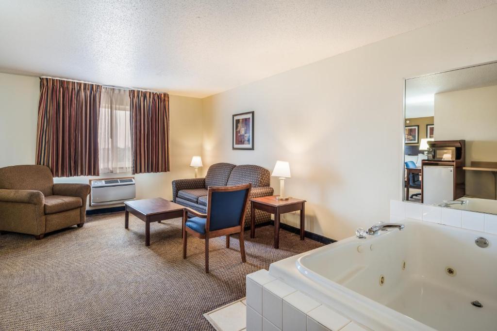 a hotel room with a tub and a living room at Quality Inn & Suites Eldridge Davenport North in Eldridge
