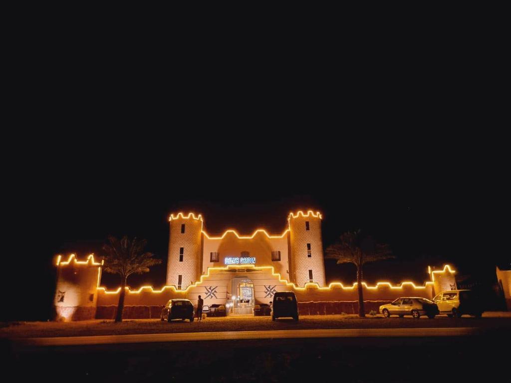 a large building with lights on it at night at Palms Garden in Erfoud