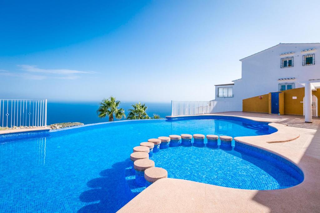 a swimming pool with the ocean in the background at Panoramic Apartment in Cumbre del Sol