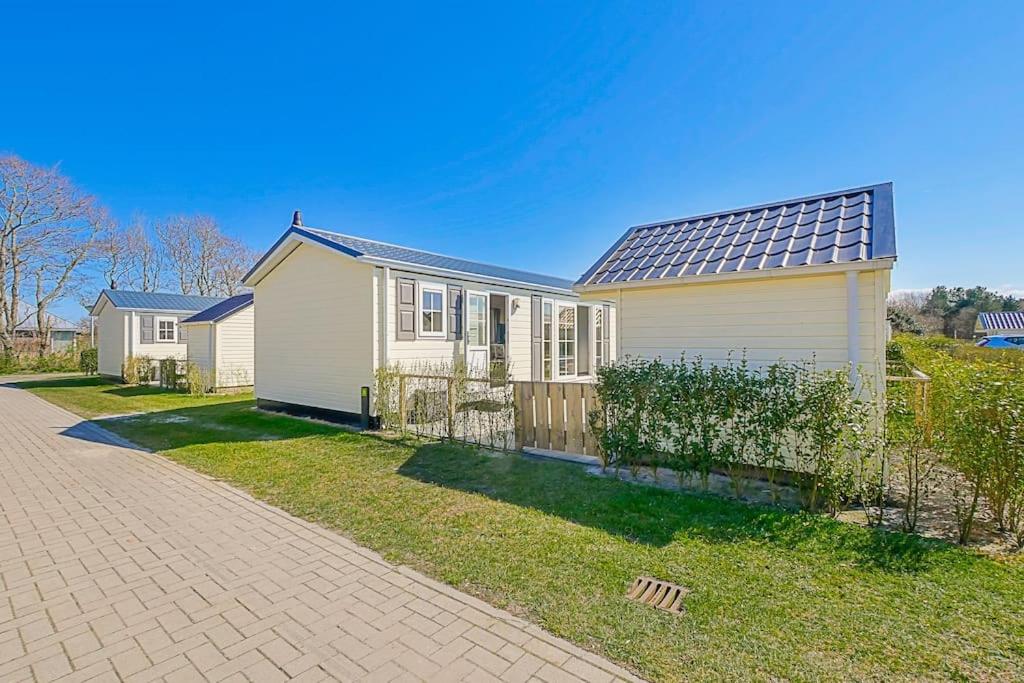 une maison blanche avec des panneaux solaires dans l'établissement Chalet Luttikduin 21, aan het strand met ruime tuin! - Callantsoog, à Callantsoog