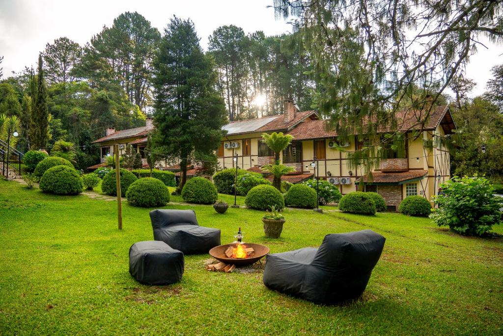 una casa con sillas y una mesa en un patio en Pousada Serra Villena, en Monte Verde