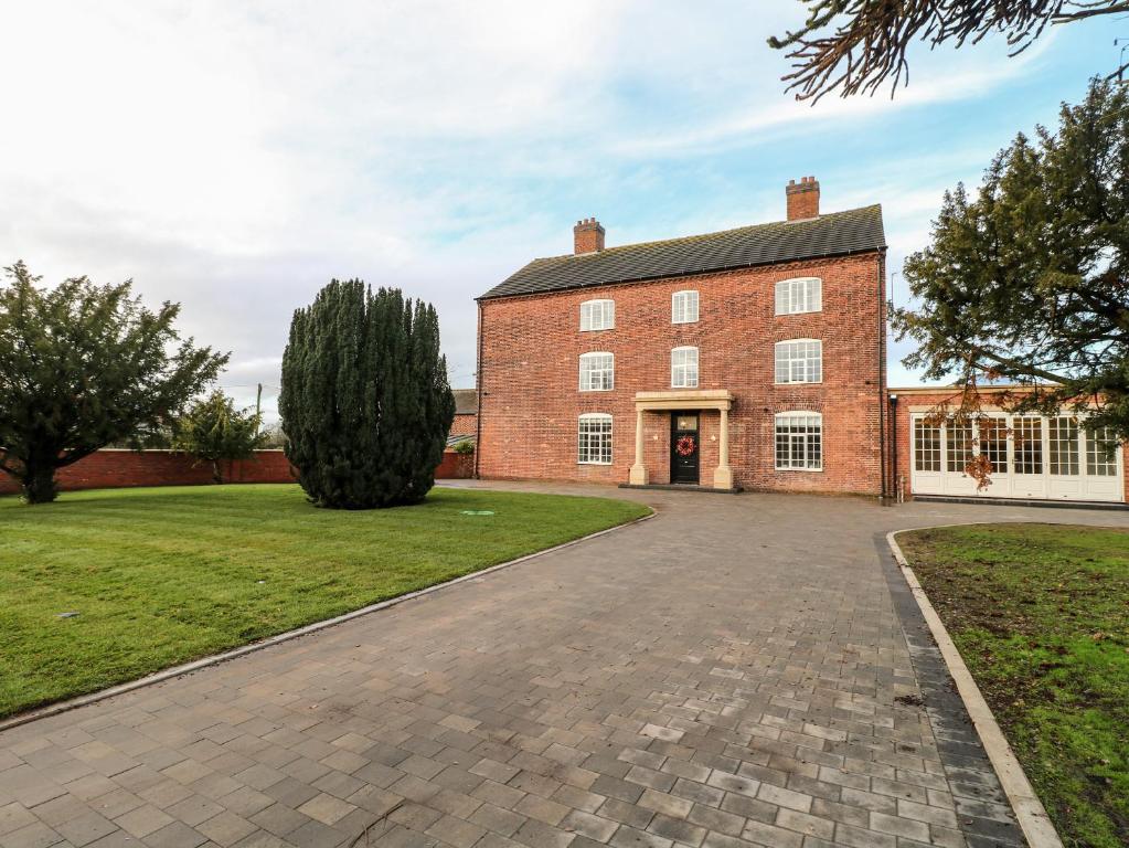 a large red brick building with a driveway at Otherton Hall in Stafford