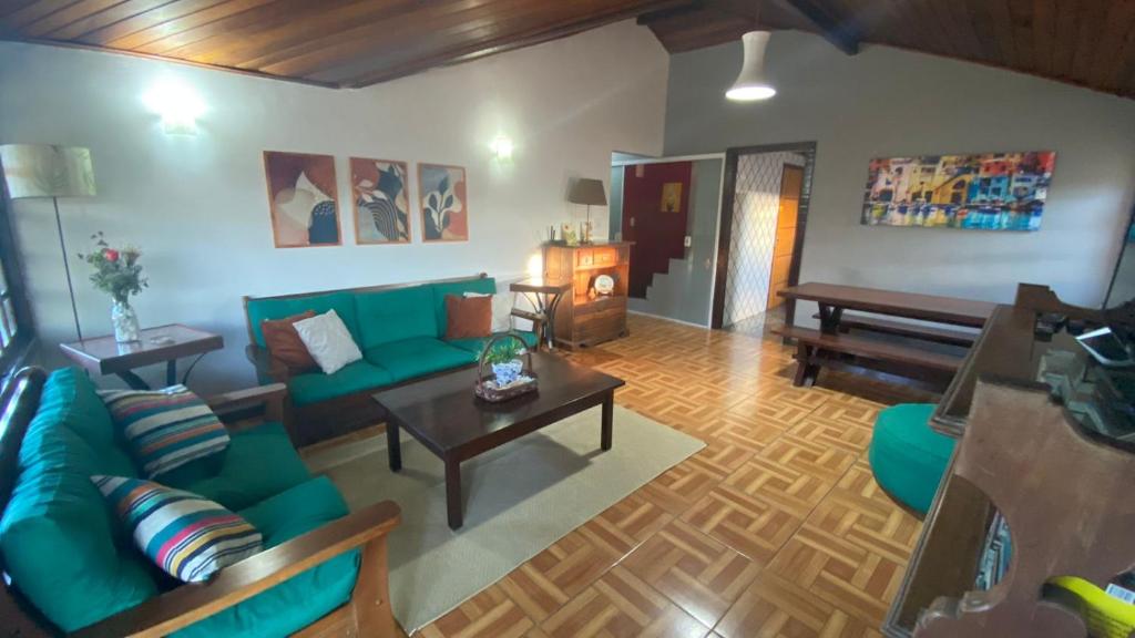 sala de estar con sofá verde y mesa en Casa de Temporada Centro Búzios, en Búzios