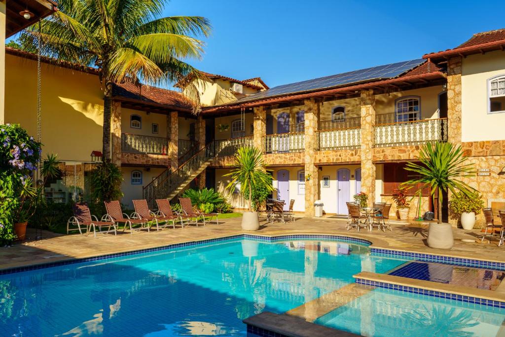 a swimming pool in front of a house at Pousada Eclipse Paraty in Paraty