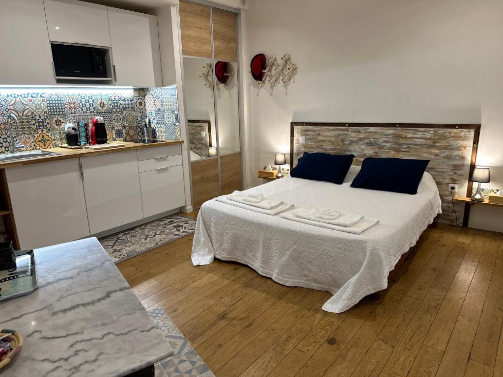 a bedroom with a large bed and a kitchen at Le studio d'Agathe centre historique - Confort & Calme in Valence