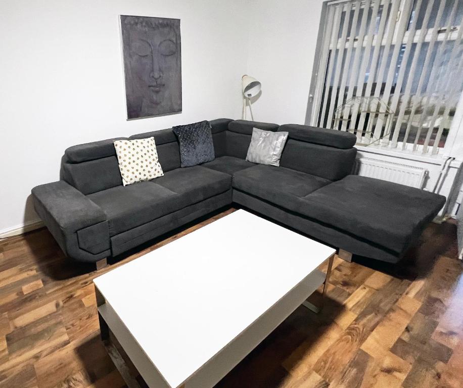 a black couch and a white table in a living room at 2 Bedroom Tudor House Pristine and Comfortable Close to Birmingham City Hospital in Birmingham