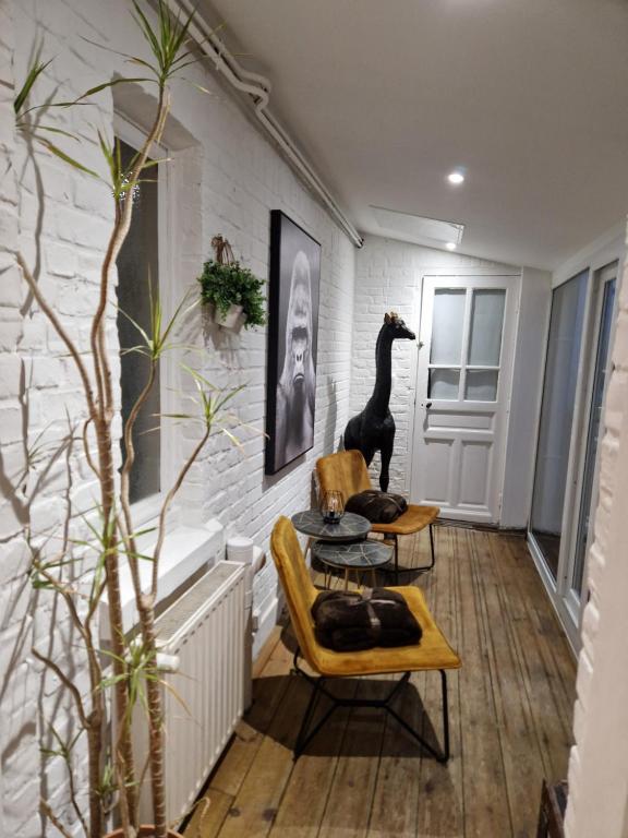 una sala de estar con una estatua de dinosaurio en la pared en Chez Lilas 150m Plage, en Dunkerque