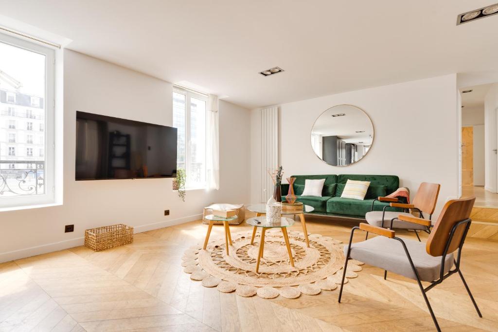 uma sala de estar com um sofá verde e uma mesa em PorteMaillot & La Défense 4 Bedroom 10 people em Neuilly-sur-Seine