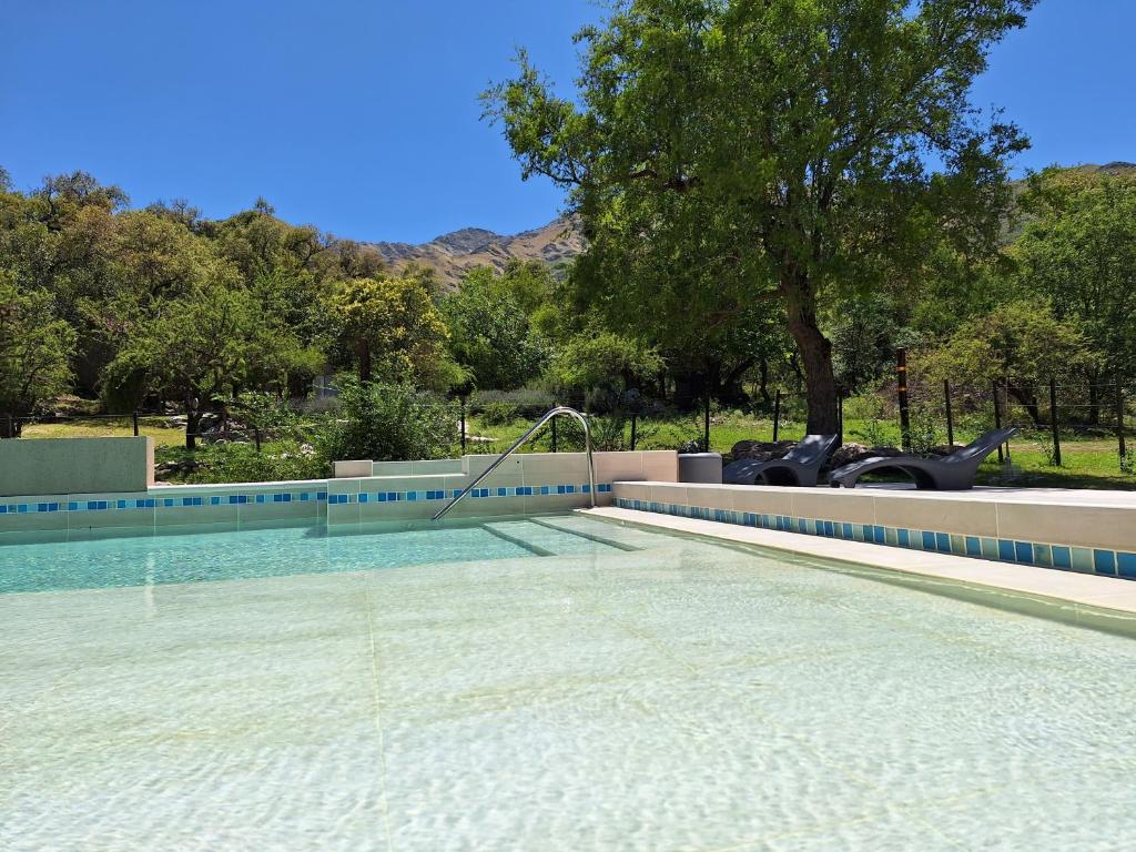 a swimming pool with a motorcycle parked next to a tree at COSTA COM Departamentos de Montaña in Merlo