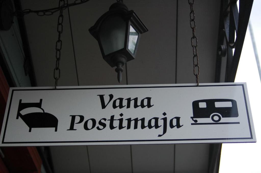Un panneau qui lit vana postimigua suspendu à un bâtiment dans l'établissement Vana Postimaja Accommodation, à Suure-Jaani