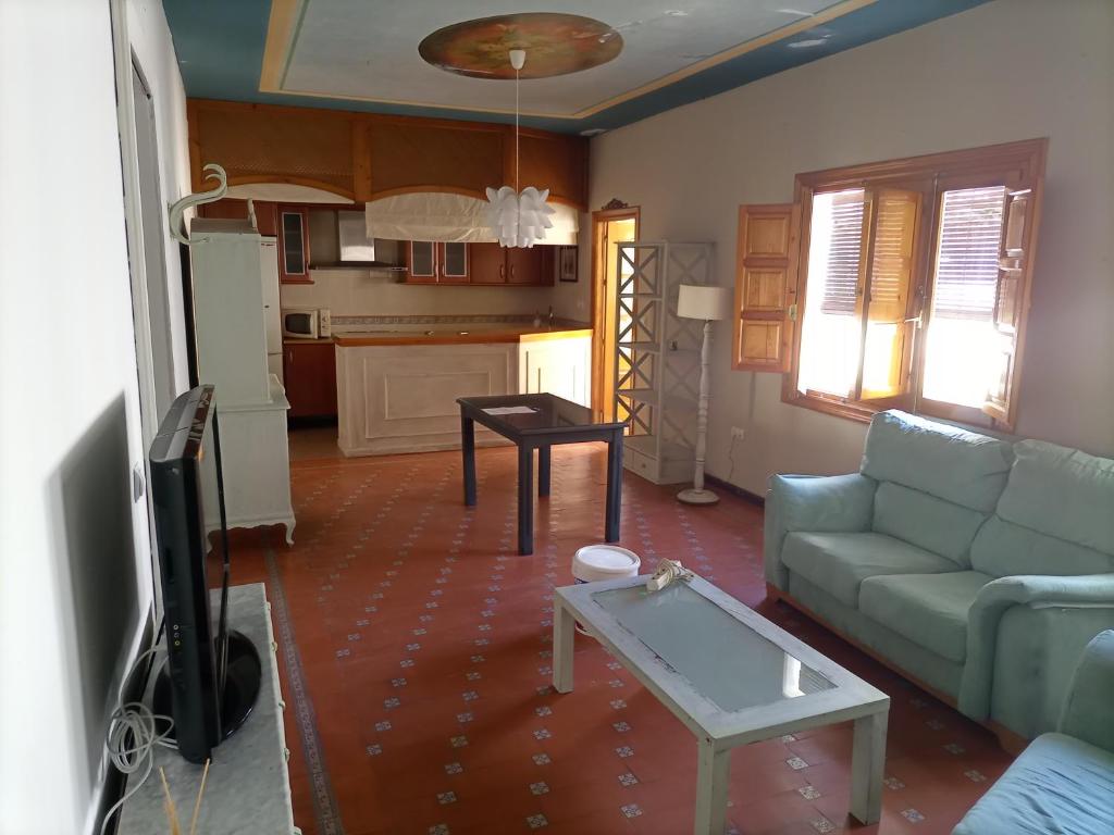 ein Wohnzimmer mit einem Sofa und einem Tisch in der Unterkunft Apartamento Granada in Atarfe