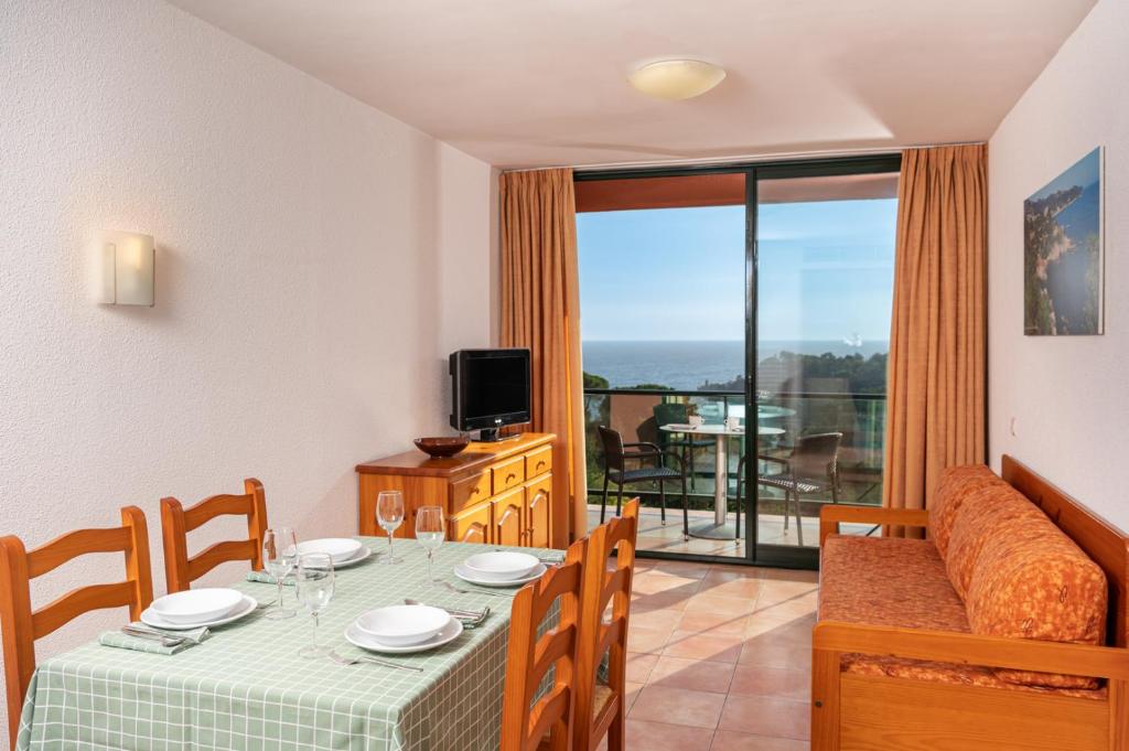 a dining room with a table and a couch at Albamar Apartaments in Lloret de Mar