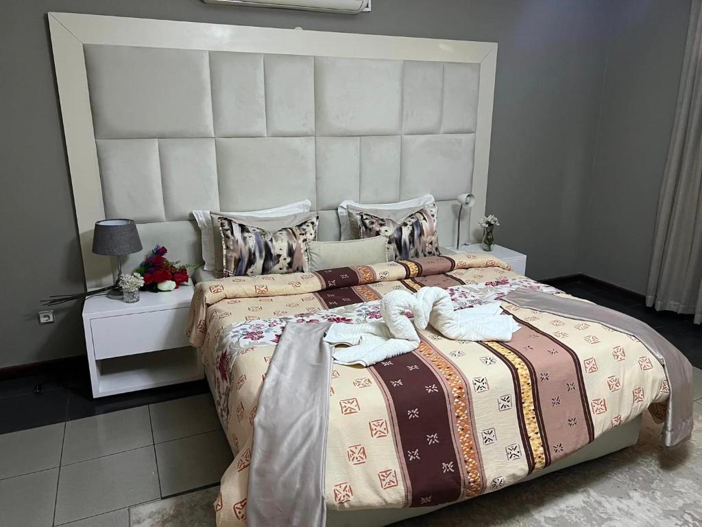 a bedroom with a large bed with a large headboard at TRMOTEL in Matola