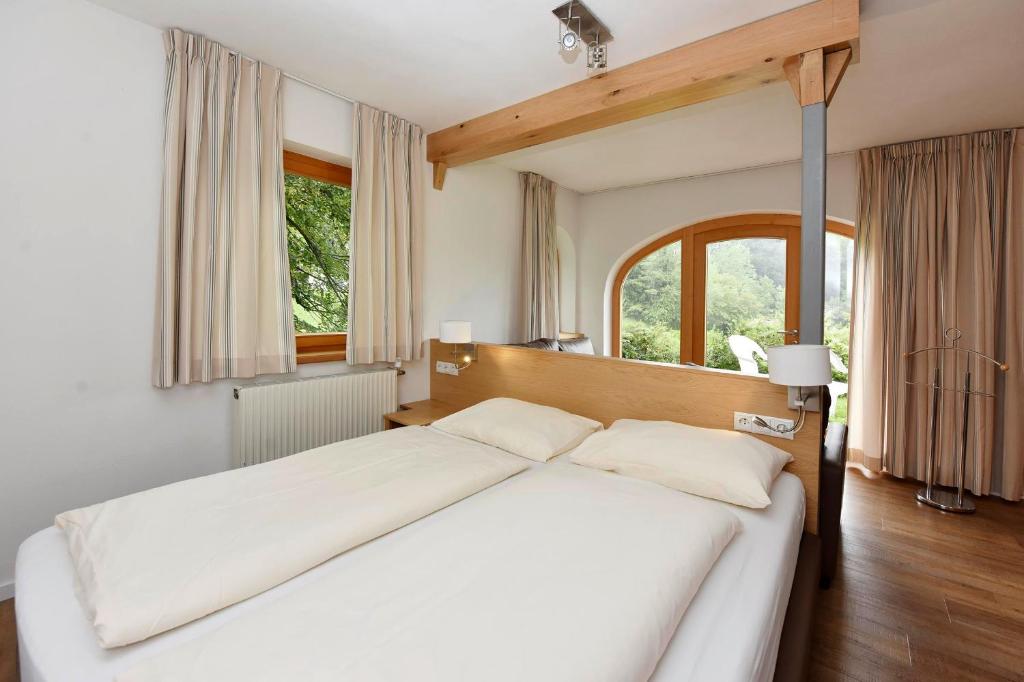 um quarto com uma grande cama branca e uma janela em Kleiner Turm 03 em Tschagguns