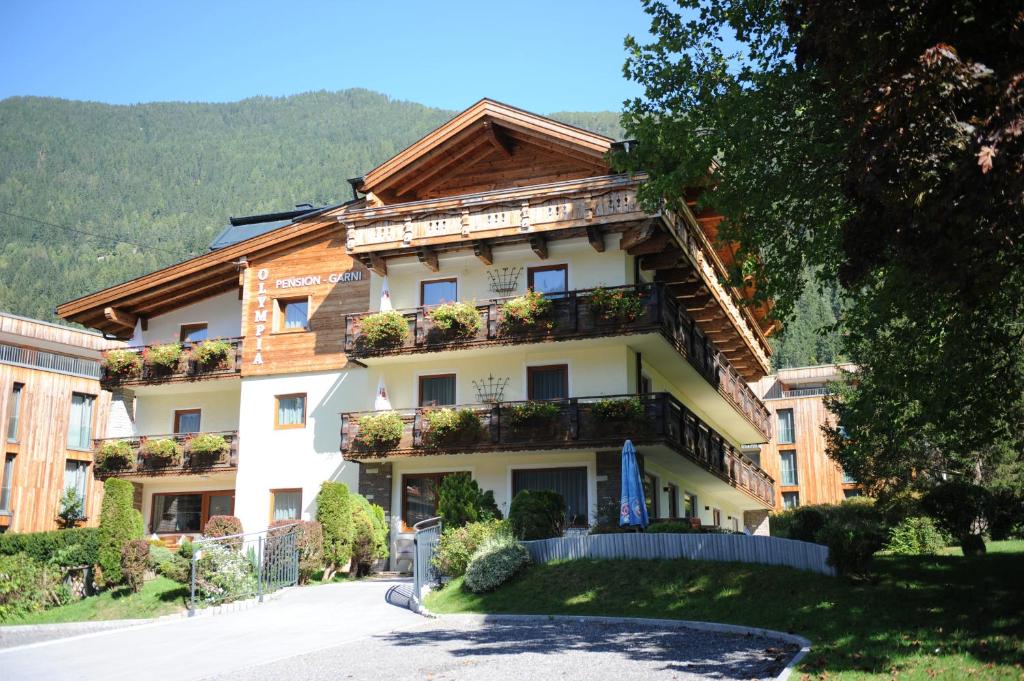 ein Gebäude mit Blumen auf den Balkonen in der Unterkunft Pension Olympia in Oetz