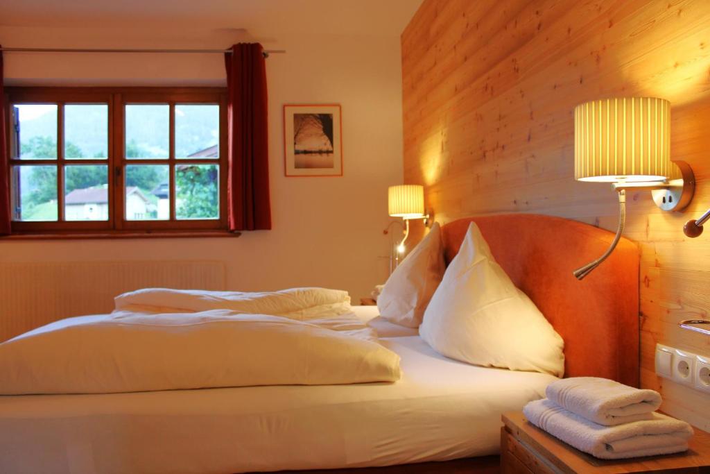 Schlafzimmer mit einem Bett mit weißer Bettwäsche und einem Fenster in der Unterkunft Kleiner Turm 4 in Tschagguns