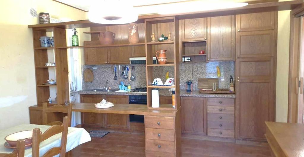 eine große Küche mit Holzschränken und einem Tisch in der Unterkunft La Corte sul Conero Casa Vacanze in Camerano