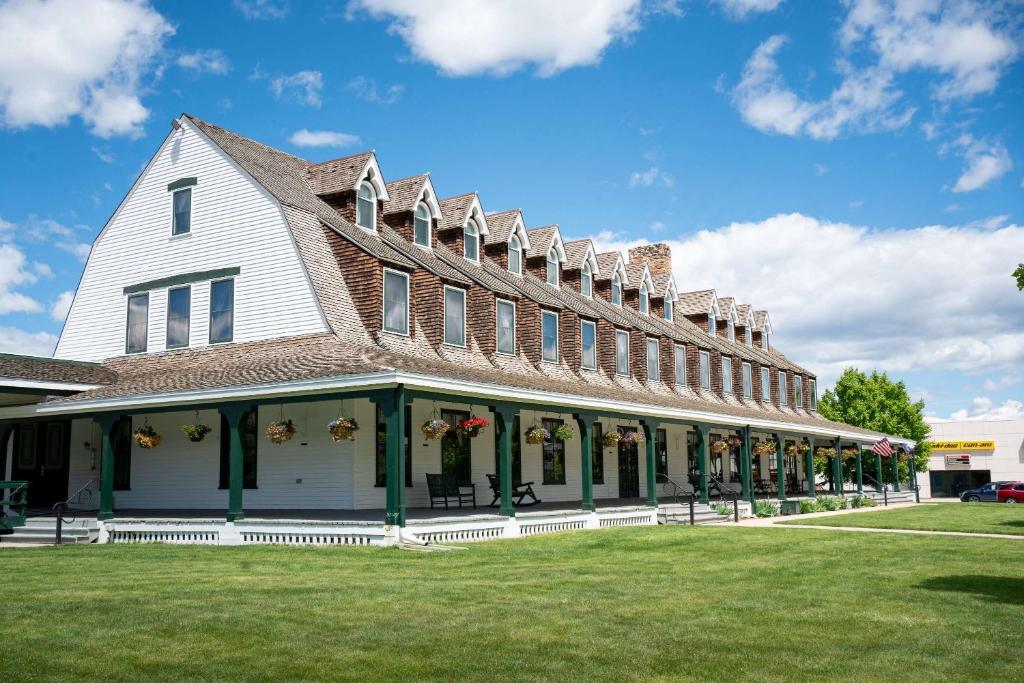 une grande maison blanche avec un toit en gambrel dans l'établissement Sheridan Inn - Best Western Signature Collection, à Sheridan