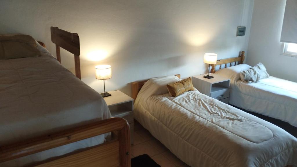 Un dormitorio pequeño con dos camas y dos lámparas. en Dúplex Iselin - Capo Bianco, en San Rafael