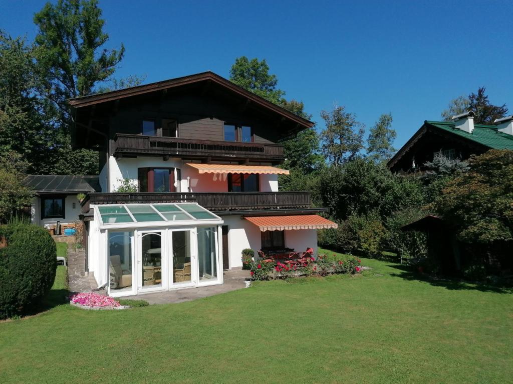 une grande maison avec une terrasse couverte et une pelouse dans l'établissement Ferienwohnung Söllner, à Kitzbühel