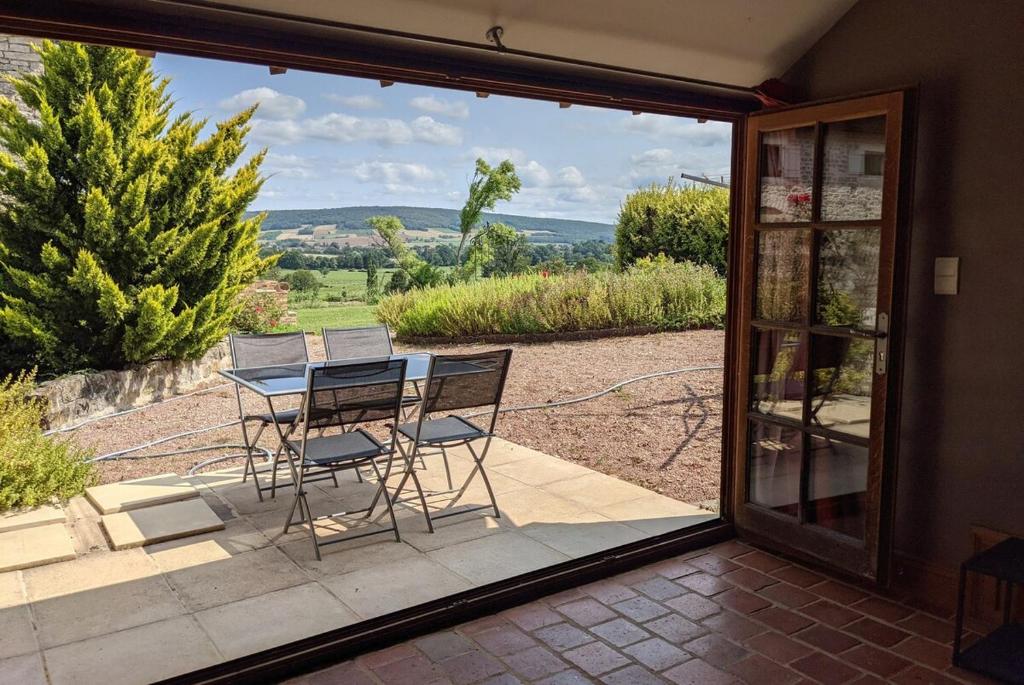 eine Terrasse mit einem Tisch und Stühlen sowie Aussicht in der Unterkunft Large Gte With Pool In Peaceful Burgundy in Sailly