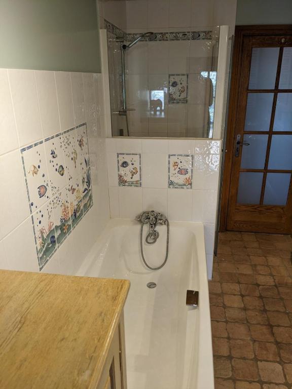ein Bad mit einer Badewanne, einer Dusche und einem Waschbecken in der Unterkunft Large Gte With Pool In Peaceful Burgundy in Sailly