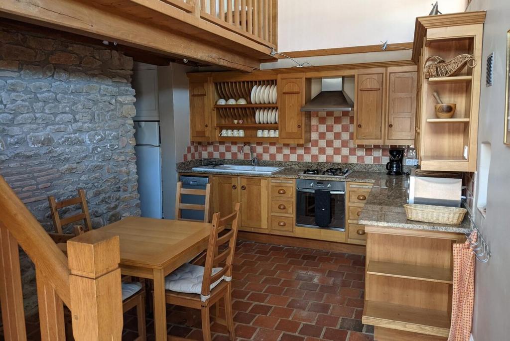 eine Küche mit Holzschränken und einem Holztisch in der Unterkunft Large Gte With Pool In Peaceful Burgundy in Sailly