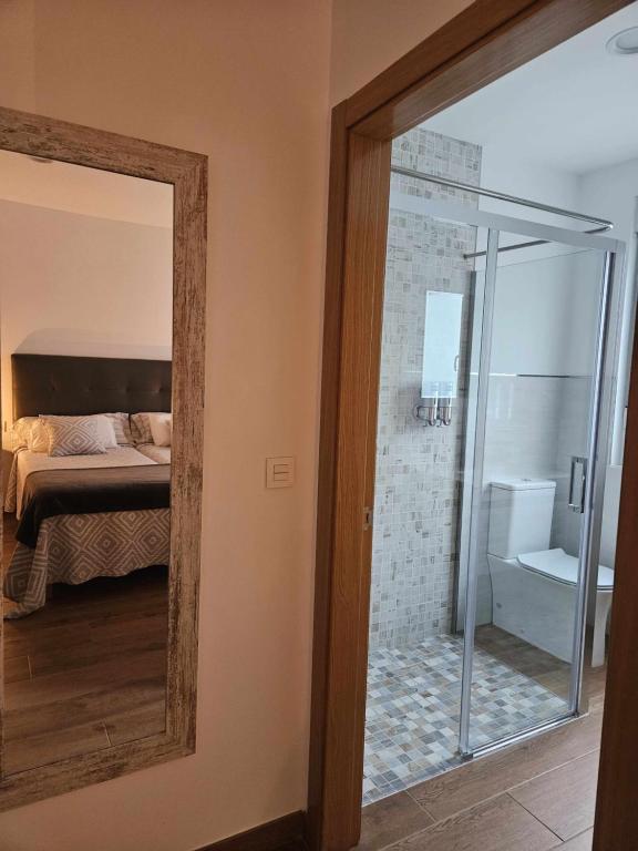 a mirror in a room with a bed and a bathroom at La Casa del Camino in Santiago de Compostela