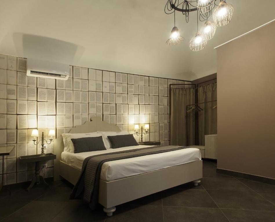 a bedroom with a large bed and a chandelier at Terrazzani Suite in Comiso