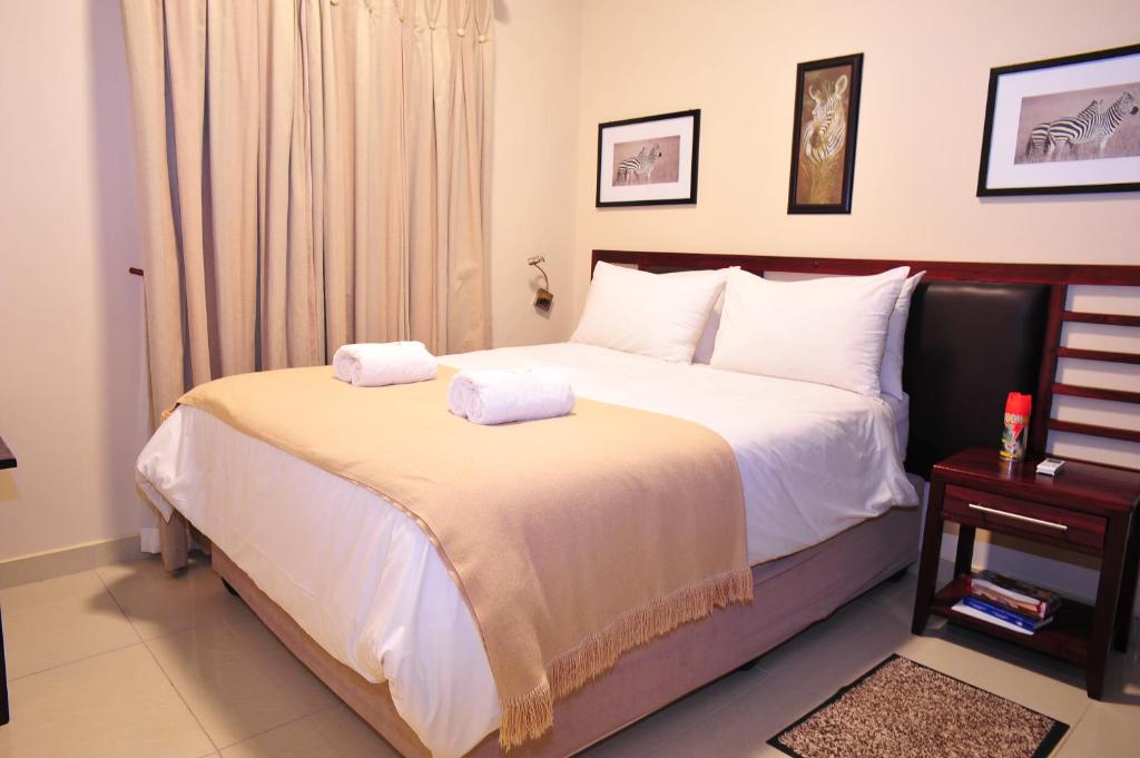 a bedroom with a bed with two towels on it at Hotel Destiny in Ongwediva