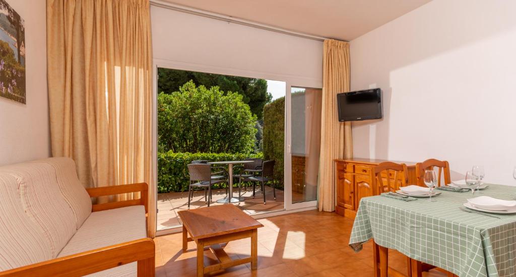 a living room with a table and a television at Albamar Apartaments in Lloret de Mar
