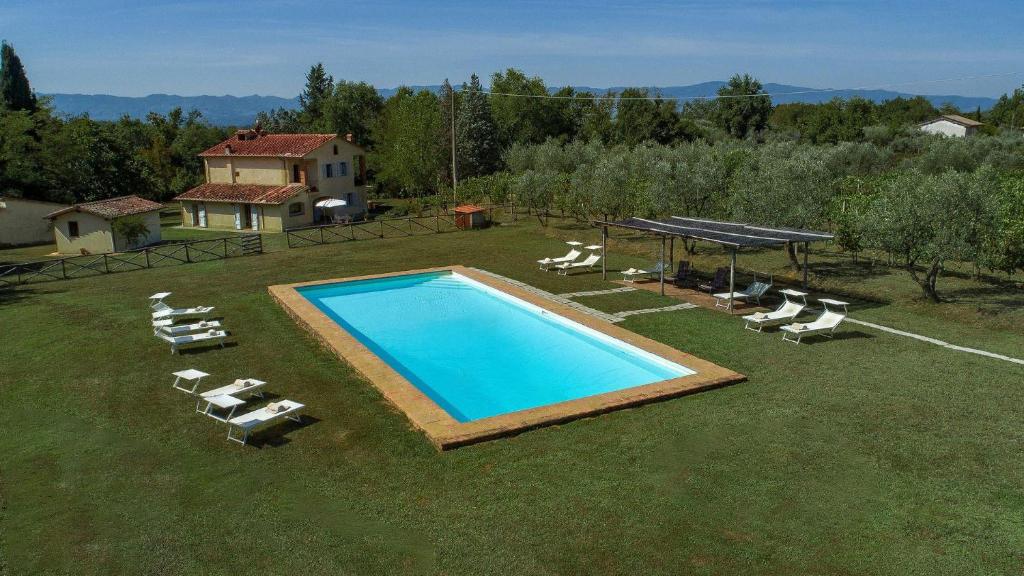 eine Aussicht über einen Pool mit Stühlen und einem Tisch in der Unterkunft Casa Campodonico 10 in Terranuova Bracciolini