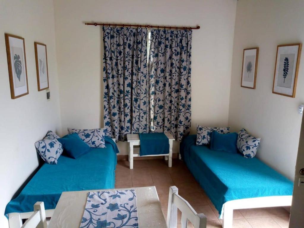 una sala de estar con 2 sofás azules y una mesa. en Azahares del Ayuí en Concordia