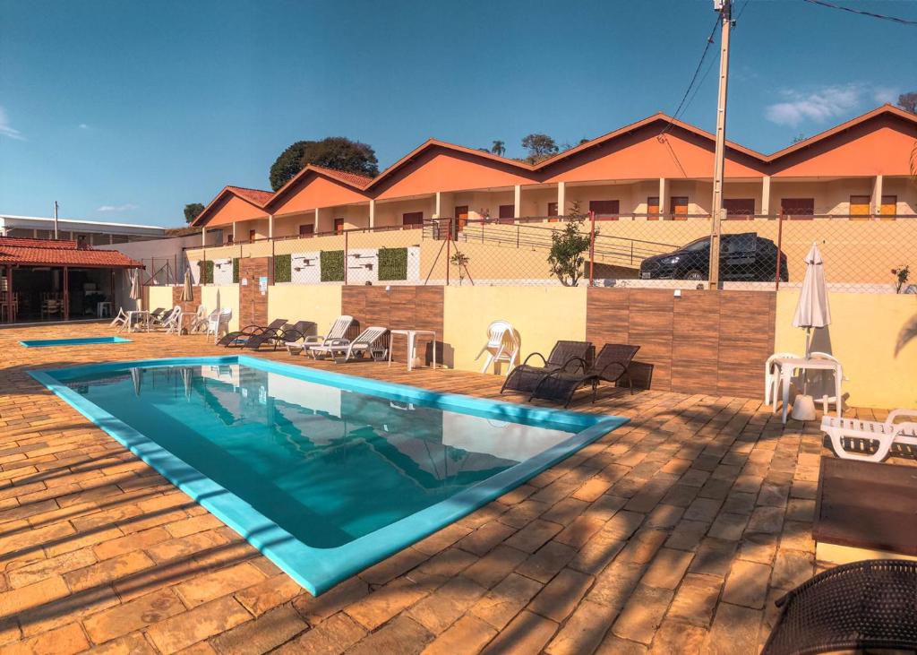 a swimming pool in front of a building at Pousada Flores do Campo in Águas de Lindóia