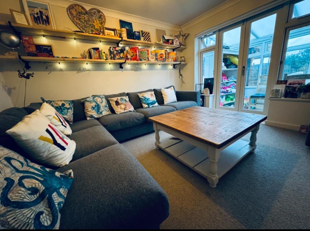 ein Wohnzimmer mit einem Sofa und einem Couchtisch in der Unterkunft West Wittering Family Home in West Wittering