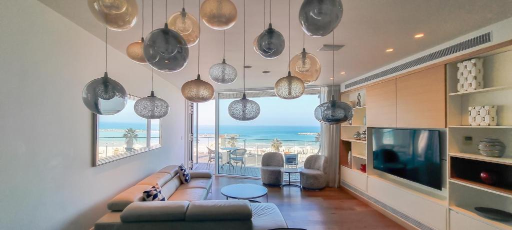 ein Wohnzimmer mit einem Sofa und Meerblick in der Unterkunft BnBIsrael apartments - Hayarkon Emeraude in Tel Aviv