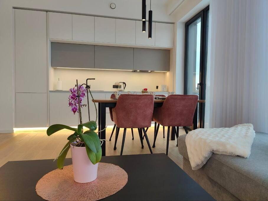 a kitchen and living room with a table and a plant at New Nordic 2BR: Beach & Forest, Family-Friendly in Tallinn