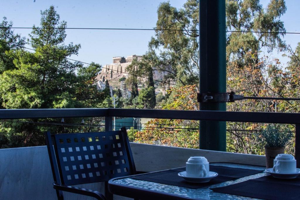 stół i krzesła na balkonie z widokiem w obiekcie Acropolis View Suites w Atenach