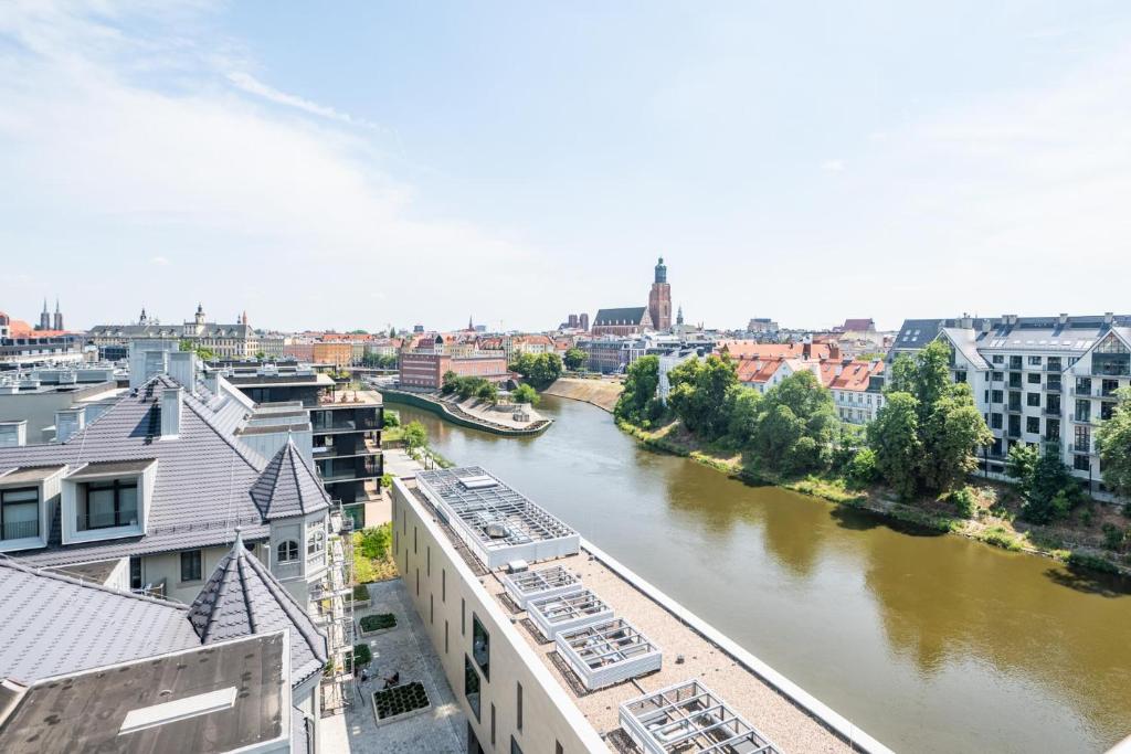 a view of a river in a city with buildings at Nice View Apartment, Free Underground Parking, City Square 6 min in Wrocław