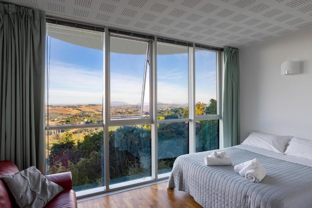 1 dormitorio con cama y ventana grande en Lo Spettacolo, en Macerata