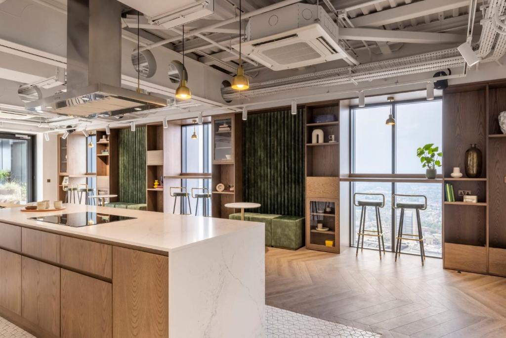 an open kitchen with a large island and bar with stools at Magnificent Apartments at Ten Degrees in Croydon in Croydon