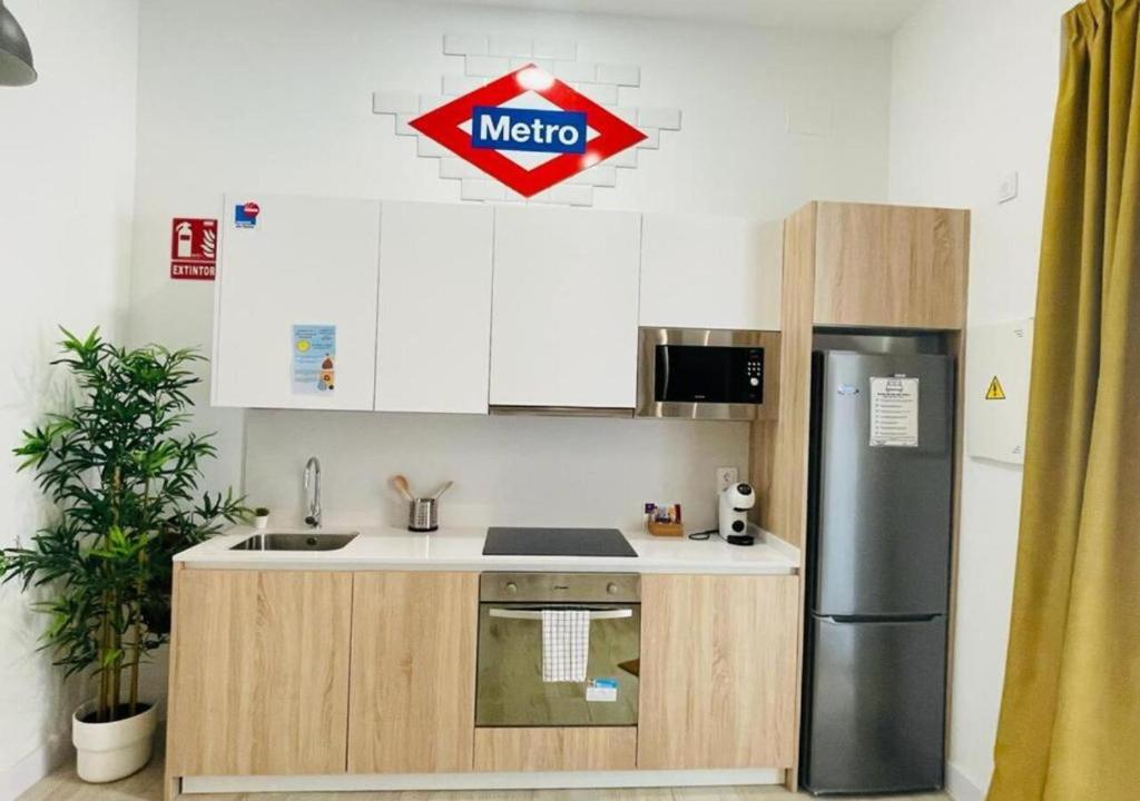 cocina con armarios blancos y nevera de acero inoxidable en (J2) Nuevo 5 personas Super centrico Retiro lujo, en Madrid