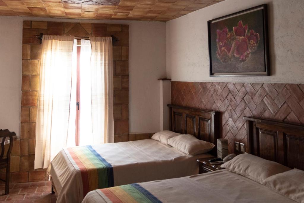 1 dormitorio con 2 camas y ventana en Hotel Casa Mixteca, en Huajuapan de León