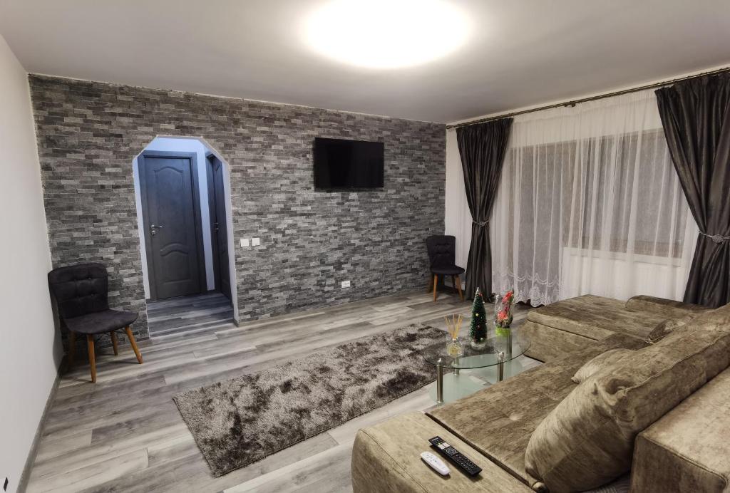 a living room with a couch and a brick wall at Apartament Epic H in Gura Humorului