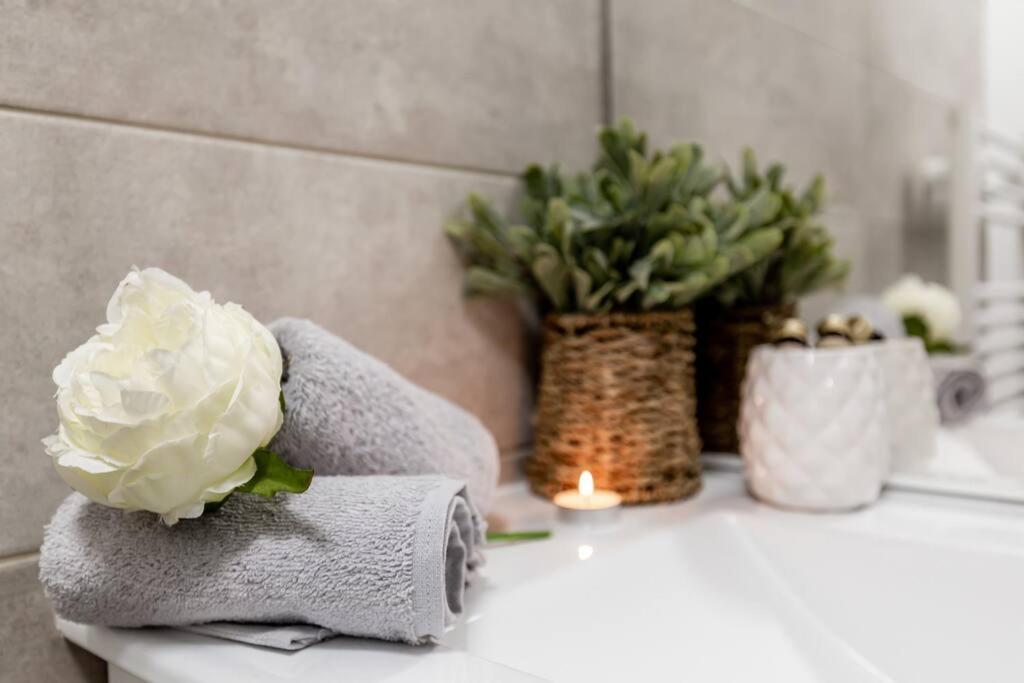 a bathroom counter with a candle and flowers on it at Grand &amp; Lumineux T2 au Coeur de Monplaisir • Métro à 2’ • Parking Privé in Lyon