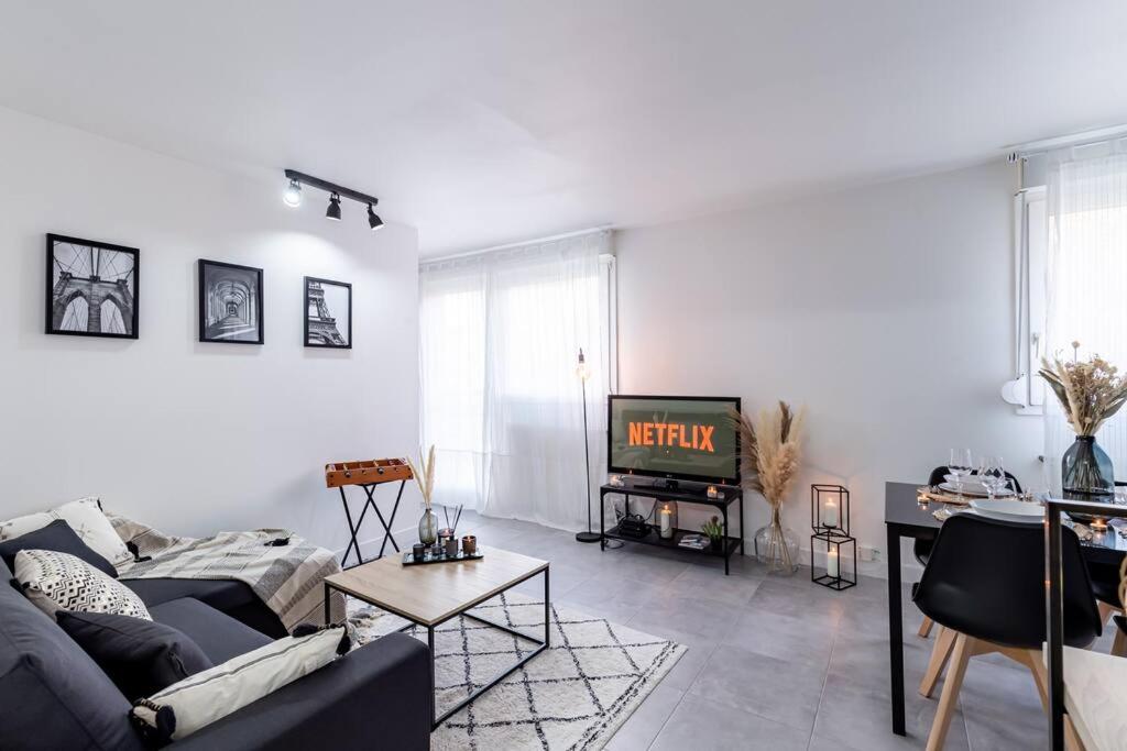 a living room with a couch and a tv at Grand &amp; Lumineux T2 au Coeur de Monplaisir • Métro à 2’ • Parking Privé in Lyon