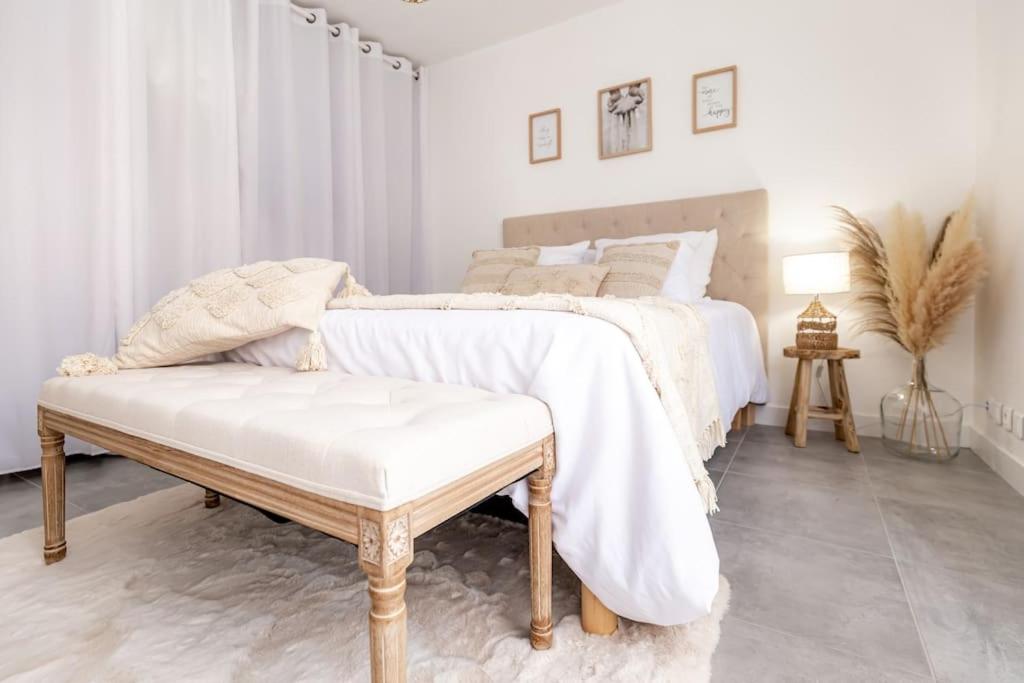 a white bedroom with a bed and a bench at Grand &amp; Lumineux T2 au Coeur de Monplaisir • Métro à 2’ • Parking Privé in Lyon
