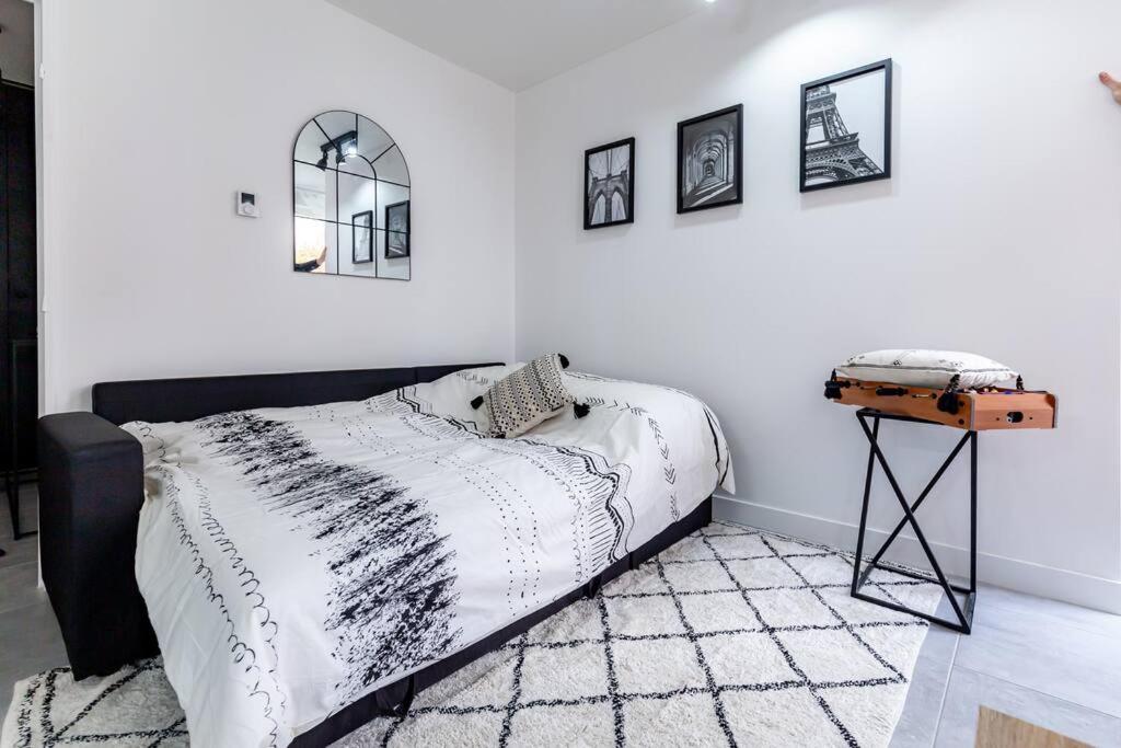 a bedroom with a black and white bed and a table at Grand &amp; Lumineux T2 au Coeur de Monplaisir • Métro à 2’ • Parking Privé in Lyon